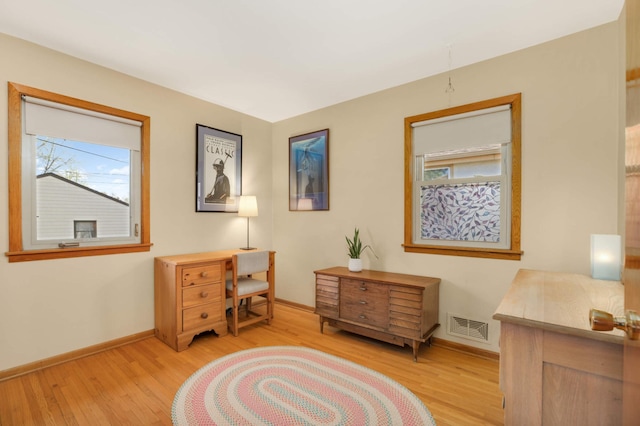 sitting room featuring baseboards, visible vents, and light wood-style flooring