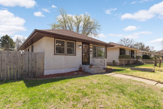 view of front of house featuring fence, a front yard, and stucco siding