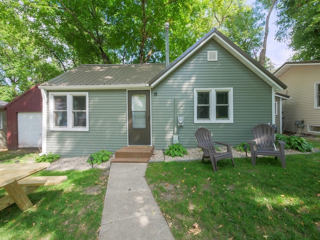 1321 Darling Dr NW, Alexandria, MN 56308 - view of front facade featuring a garage, a front lawn, and metal roof