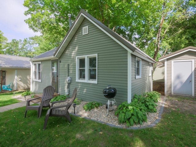 1321 Darling Dr NW, Alexandria, MN 56308 - back of house with a lawn, an outdoor structure, and a storage unit