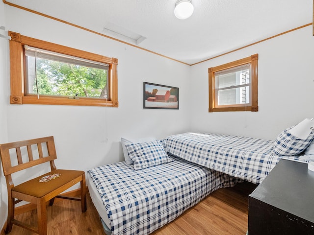 1321 Darling Dr NW, Alexandria, MN 56308 - bedroom featuring attic access, wood finished floors, and crown molding