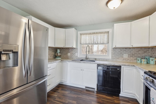 kitchen featuring dark wood-type flooring, white cabinetry, a sink, light countertops, and stainless steel appliances