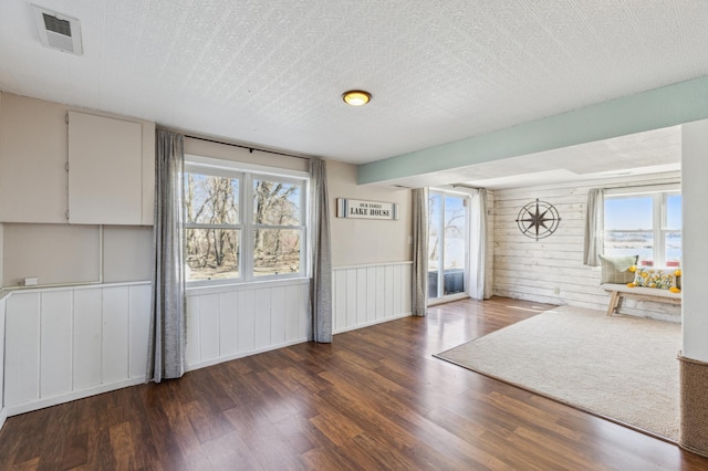 interior space featuring a wealth of natural light, visible vents, and wood finished floors