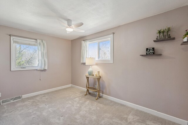 spare room with visible vents, ceiling fan, carpet, and baseboards