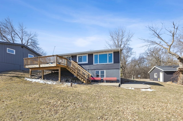 back of property featuring a yard, a wooden deck, and stairs