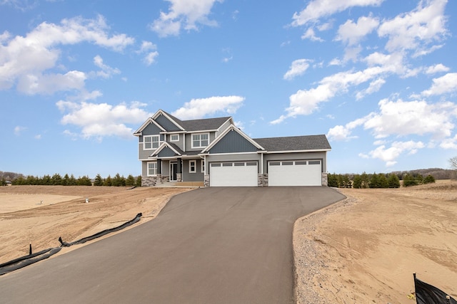 21057 Tippecanoe St NE, East Bethel, MN 55011 - craftsman inspired home with stone siding, an attached garage, and driveway