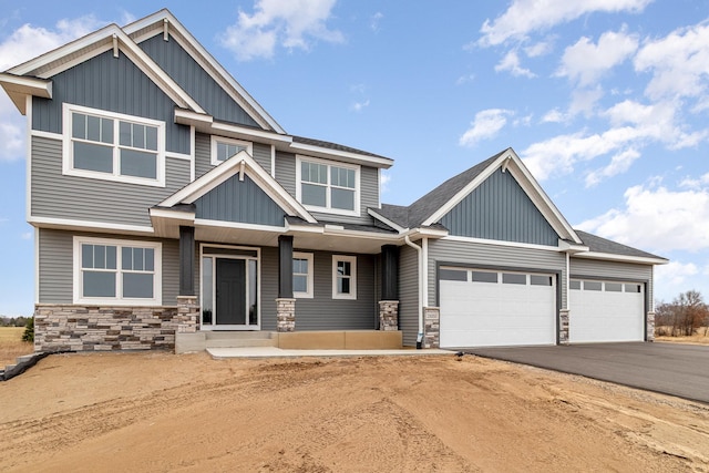 21057 Tippecanoe St NE, East Bethel, MN 55011 - craftsman inspired home with stone siding, board and batten siding, asphalt driveway, an attached garage, and a porch