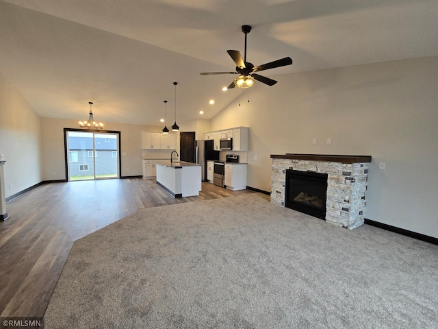 602 Warren St, Janesville, MN 56048 - unfurnished living room with a stone fireplace, ceiling fan with notable chandelier, and baseboards