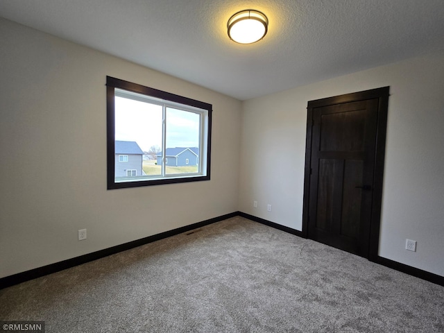 602 Warren St, Janesville, MN 56048 - empty room with baseboards, carpet floors, and a textured ceiling