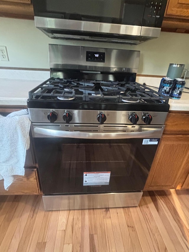 3865 Westbury Ln, Eagan, MN 55123 - detailed view of stainless steel appliances, brown cabinets, and light wood finished floors