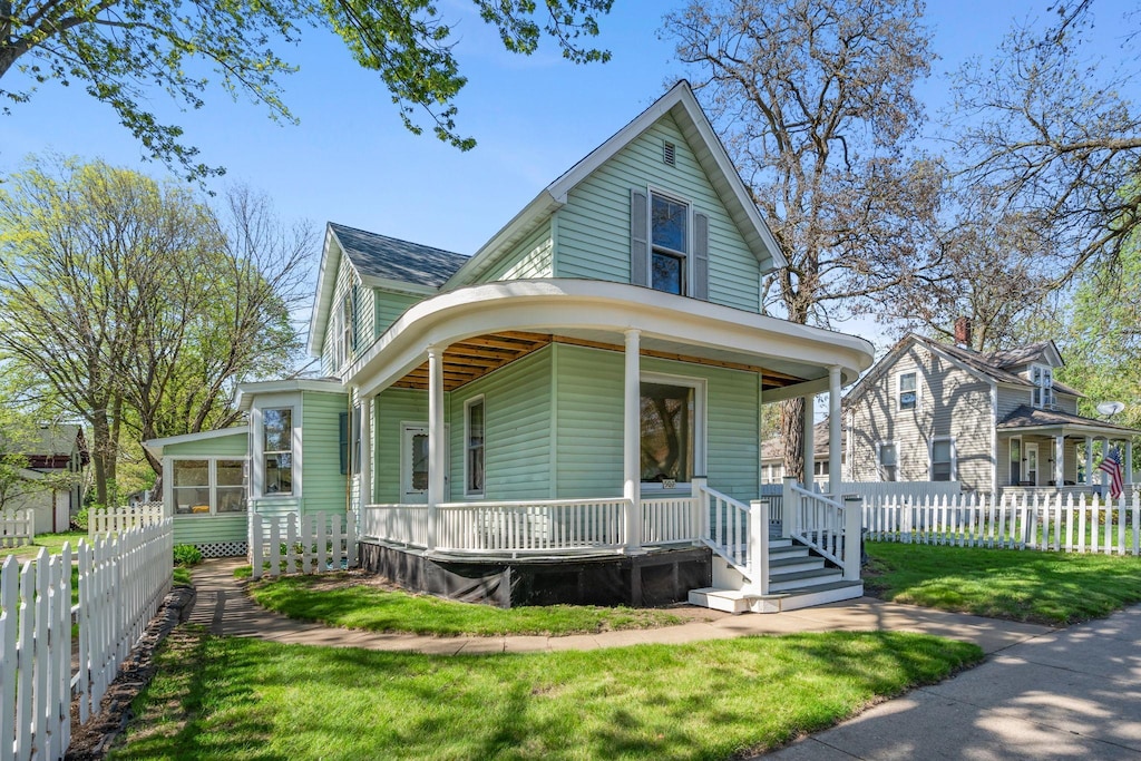 507 Cascade St N, Osceola, WI 54020 - view of front of property with a porch, a shingled roof, and a sunroom