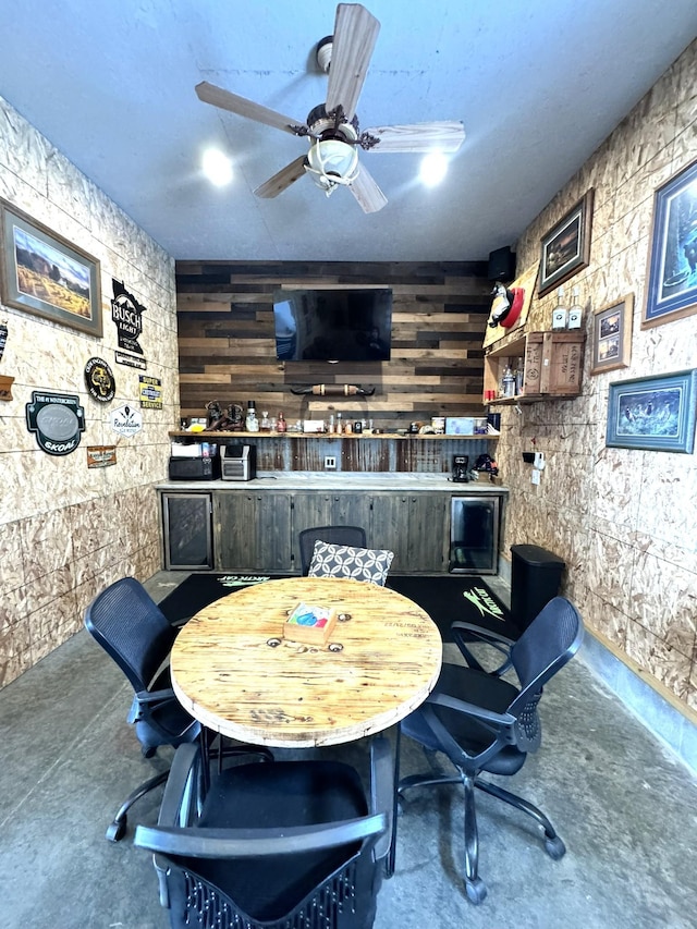 12863 170th St, Park Rapids, MN 56470 - dining room with ceiling fan, concrete floors, and wooden walls