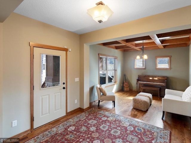 foyer with baseboards, wood finished floors, coffered ceiling, and beamed ceiling