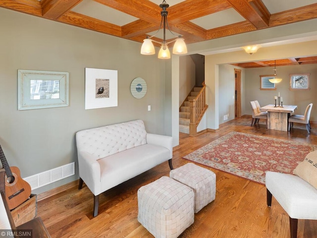 living area with wood finished floors, stairs, coffered ceiling, beamed ceiling, and baseboards