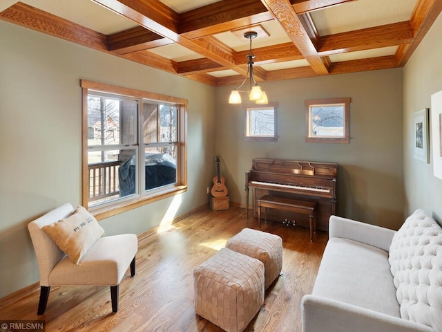 living area featuring beamed ceiling, coffered ceiling, wood finished floors, and baseboards