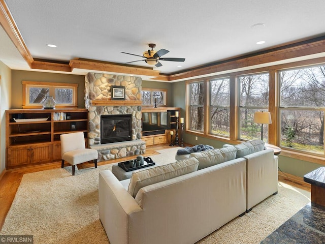 living room featuring ceiling fan, baseboards, recessed lighting, a fireplace, and wood finished floors