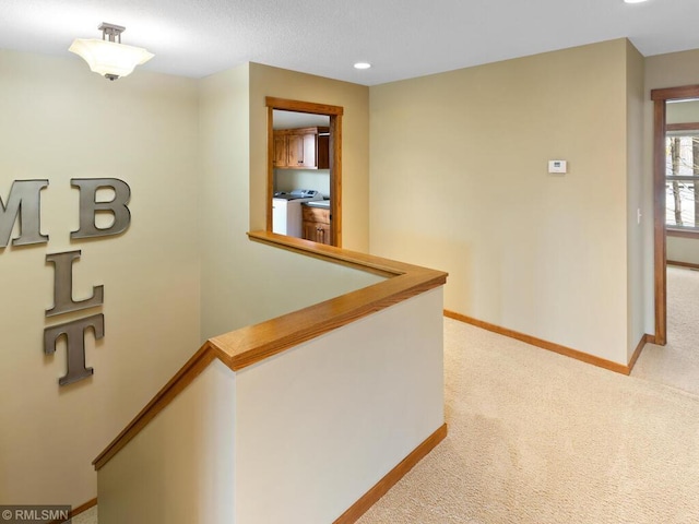 hall featuring recessed lighting, light carpet, an upstairs landing, baseboards, and washer / clothes dryer