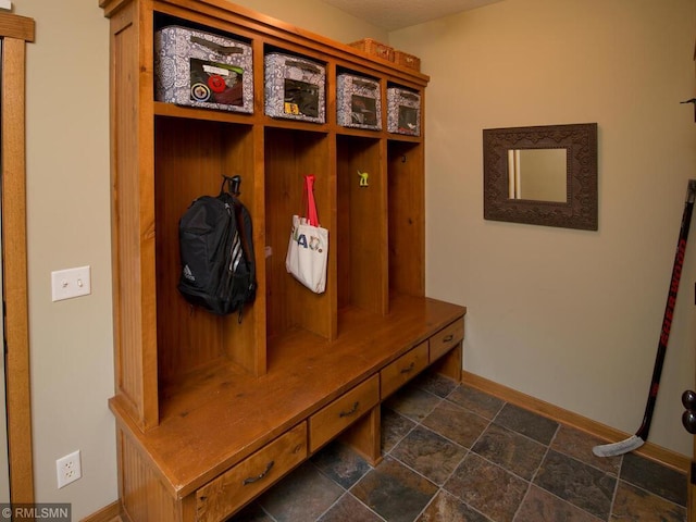 mudroom with stone finish floor and baseboards