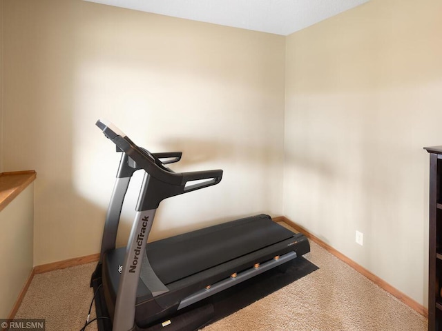 workout area featuring carpet and baseboards