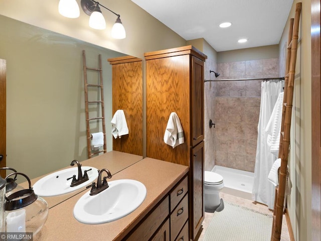 bathroom with recessed lighting, vanity, toilet, a tile shower, and tile patterned flooring
