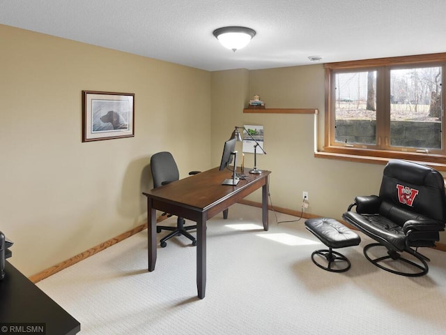 office space featuring a textured ceiling, carpet flooring, and baseboards