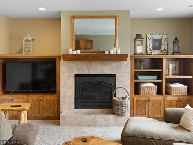 living room featuring a tiled fireplace and recessed lighting