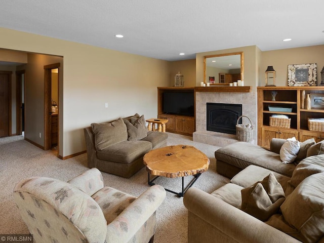 living area featuring a tiled fireplace, recessed lighting, light colored carpet, and baseboards