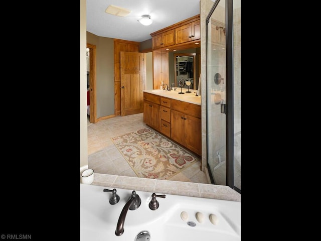 bathroom with tile patterned floors, double vanity, a bath, a sink, and a stall shower