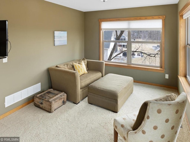 living area featuring carpet, visible vents, and baseboards