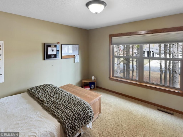 carpeted bedroom featuring visible vents and baseboards