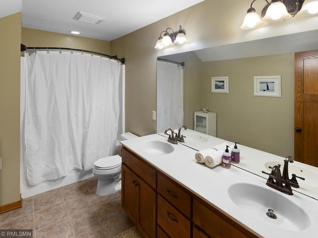 full bathroom featuring double vanity, toilet, and a sink