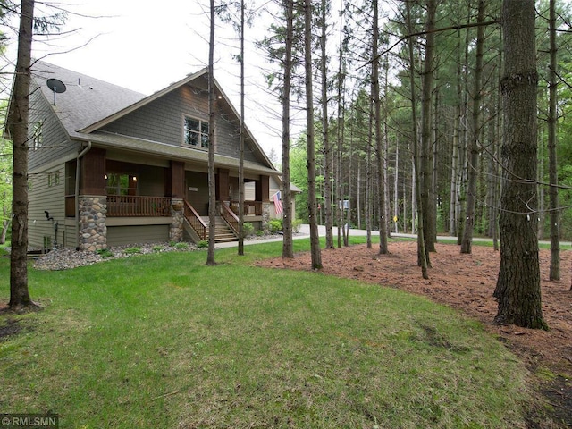 exterior space featuring a porch, a front lawn, stairs, and stone siding