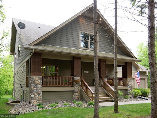 view of front facade featuring roof with shingles, stairs, and a porch