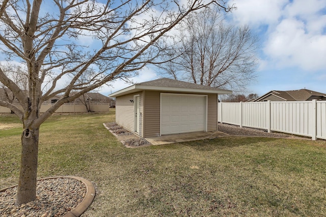 view of yard featuring a detached garage, an outdoor structure, and driveway