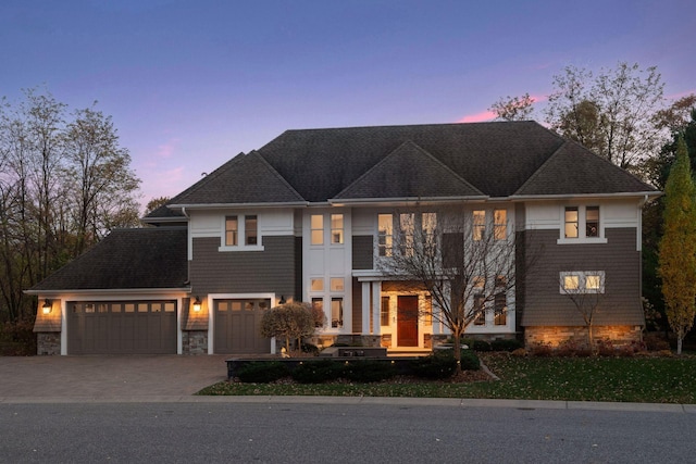 view of front of home featuring stone siding, a garage, and driveway