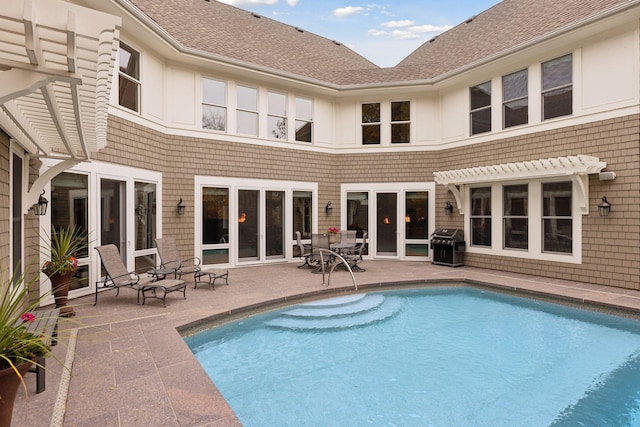 view of swimming pool with grilling area, a patio, and a pergola