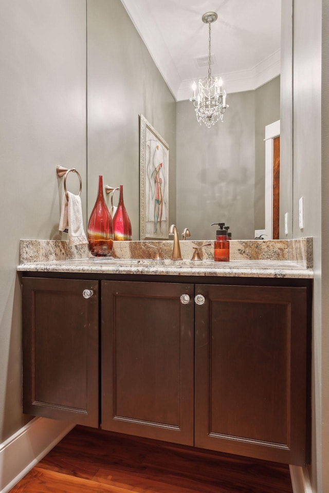 bathroom with crown molding, visible vents, an inviting chandelier, and vanity