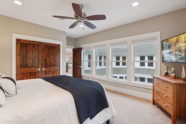 bedroom with a closet, light colored carpet, baseboards, and recessed lighting