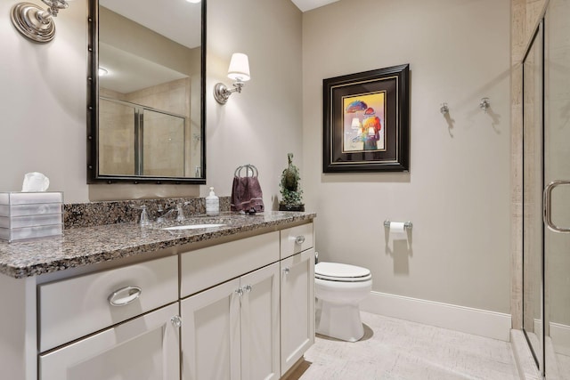 full bathroom with toilet, a stall shower, baseboards, and vanity