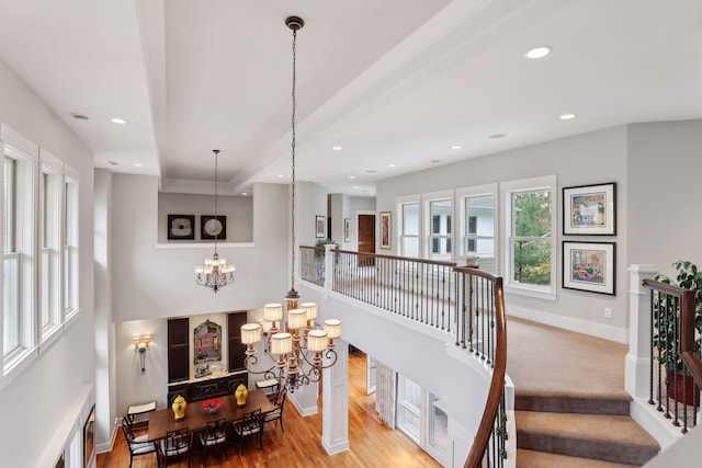 stairway featuring a chandelier, recessed lighting, baseboards, and wood finished floors
