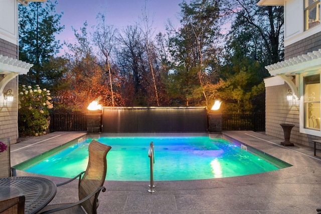 pool at dusk with a patio, a fenced backyard, and a fenced in pool