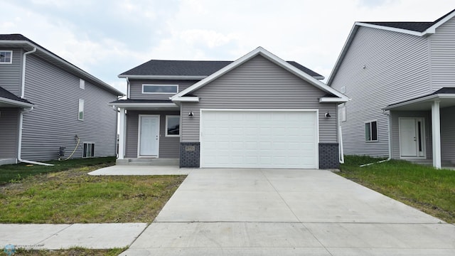 6730 70th Ave S, Horace, ND 58047 - view of front of house with driveway, an attached garage, brick siding, and a front lawn