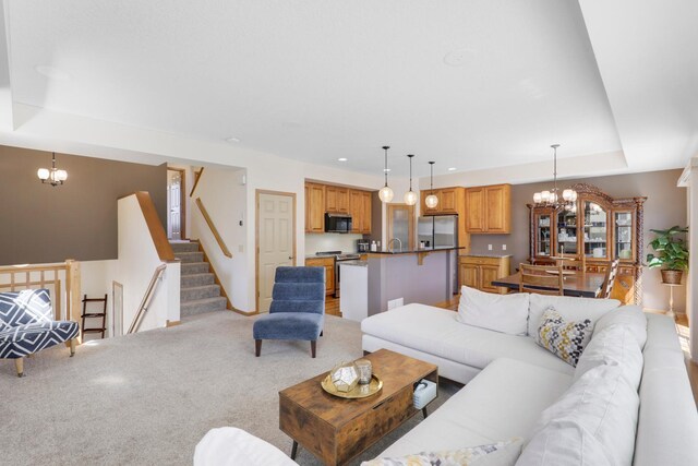 2923 124th Cir NE, Blaine, MN 55449 - living room featuring a chandelier, a raised ceiling, light carpet, stairway, and baseboards