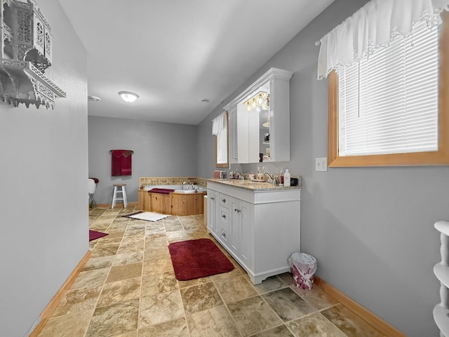 4886 Feelinrite Ln NW, Eckles Twp, MN 56601 - bathroom with baseboards, stone finish flooring, and vanity