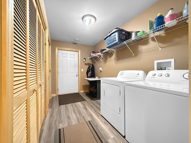 4886 Feelinrite Ln NW, Eckles Twp, MN 56601 - laundry area featuring washing machine and clothes dryer, light wood-style flooring, and baseboards