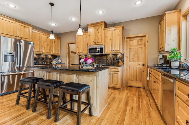 17623 Grist Ct SW, Prior Lake, MN 55372 - kitchen with stainless steel appliances, a sink, a kitchen bar, light wood-type flooring, and a center island