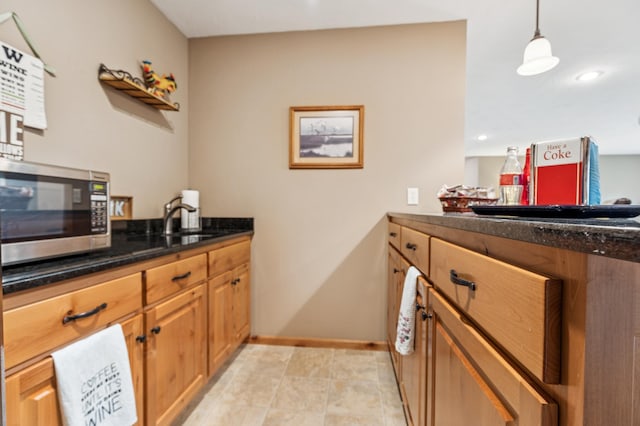 17623 Grist Ct SW, Prior Lake, MN 55372 - kitchen featuring stainless steel microwave, a sink, dark stone countertops, baseboards, and brown cabinets