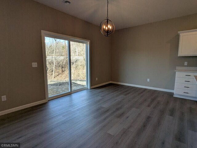 6752 104th St, Cottage Grove, MN 55016 - unfurnished dining area with dark wood-style flooring, a chandelier, and baseboards