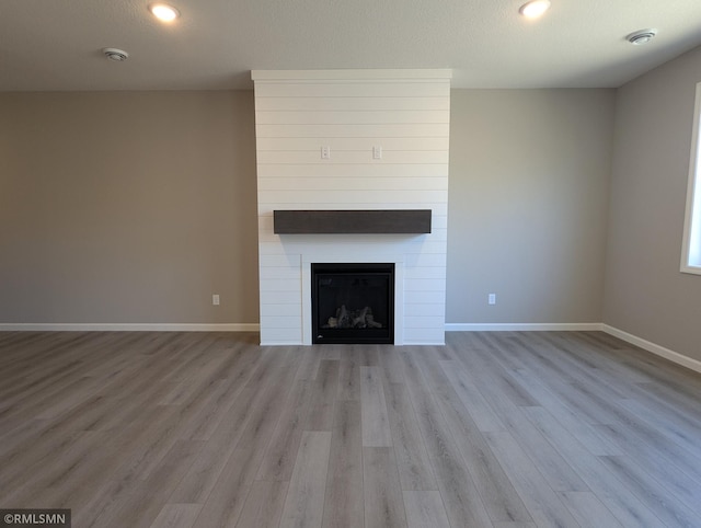 6752 104th St, Cottage Grove, MN 55016 - unfurnished living room with wood finished floors, a large fireplace, baseboards, and recessed lighting