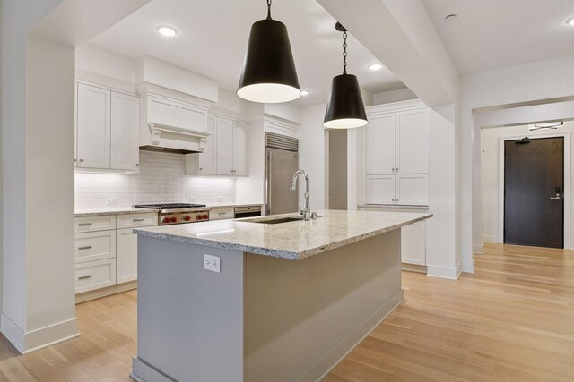 222 Ferndale Rd S Unit 207, Wayzata, MN 55391 - kitchen featuring appliances with stainless steel finishes, light wood-style flooring, backsplash, a kitchen island with sink, and white cabinets